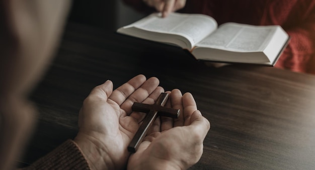 Aproximação de um simples colar de cruz cristão de madeira na Bíblia Conceito de esperança fé religião cristandade