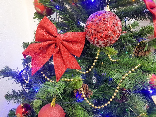 Aproximação de uma árvore de Natal decorada com arcos espumantes bolas de vidro e brinquedos de árvores de Natal