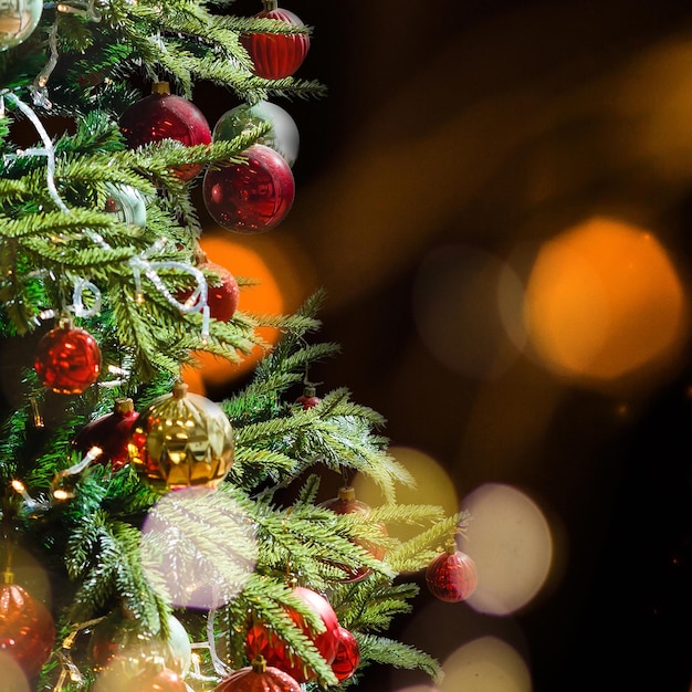 Aproximação de uma bugiganga vermelha pendurada em uma árvore de Natal decorada