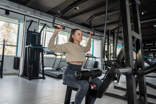 Aproximação de uma jovem esportiva em roupas esportivas exibindo seu corpo bem treinado