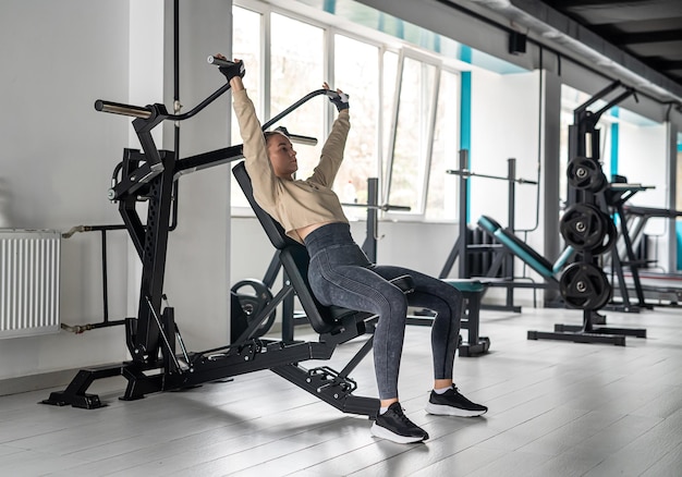 Aproximação de uma jovem esportiva em roupas esportivas exibindo seu corpo bem treinado