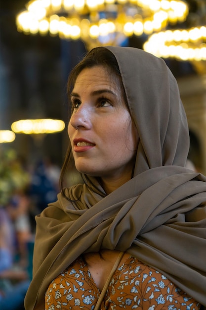 Aproximação de uma jovem turista velada visitando o interior da mesquita Hagia Sophia