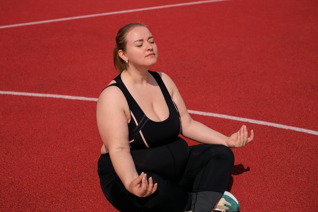 Aproximação de uma mulher gorda forte e confiante envolvida em meditação