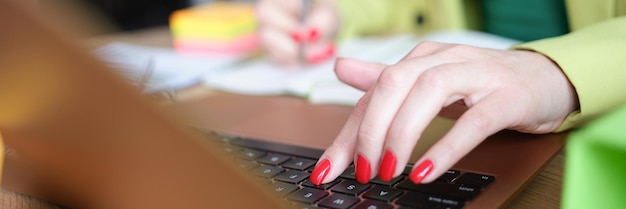 Aproximação de uma mulher ocupada trabalhando em casa usa um laptop moderno para comunicação na web e
