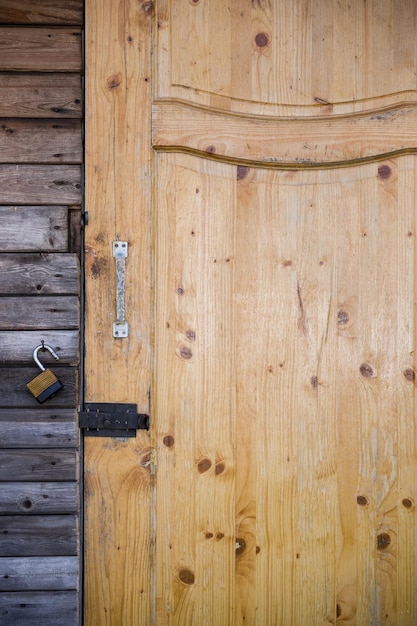 Aproximação de uma porta de madeira com fechadura em uma antiga casa de jardim