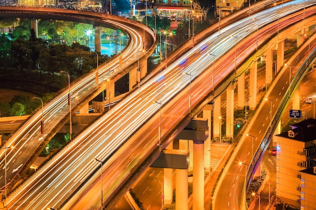 Aproximação do viaduto no tráfego noturno com trilhas leves xA