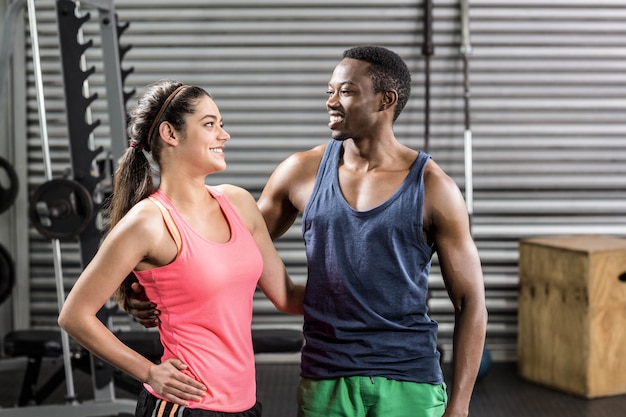 Apto casal posando juntos no ginásio crossfit