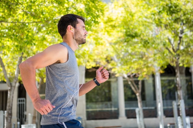 Apuesto atleta corriendo en la calle