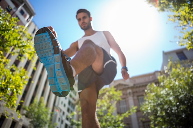 Apuesto atleta corriendo en la calle