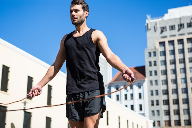 Apuesto atleta haciendo saltar la cuerda