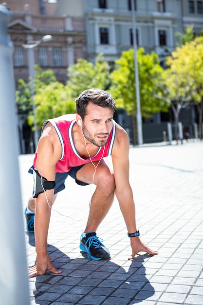 Apuesto atleta en posición de correr