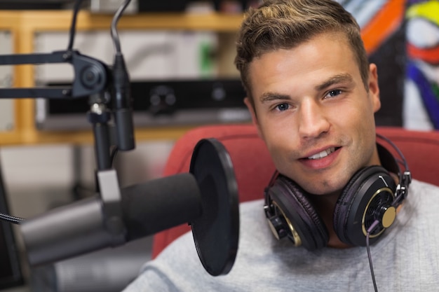 Foto apuesto cantante sonriente grabando una canción