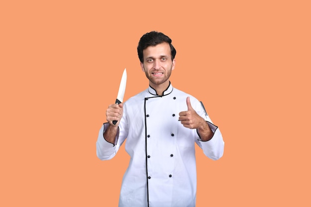 Apuesto chef cocinero traje blanco con cuchillo modelo paquistaní indio