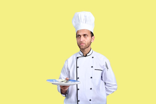 Apuesto chef sosteniendo un plato modelo paquistaní indio