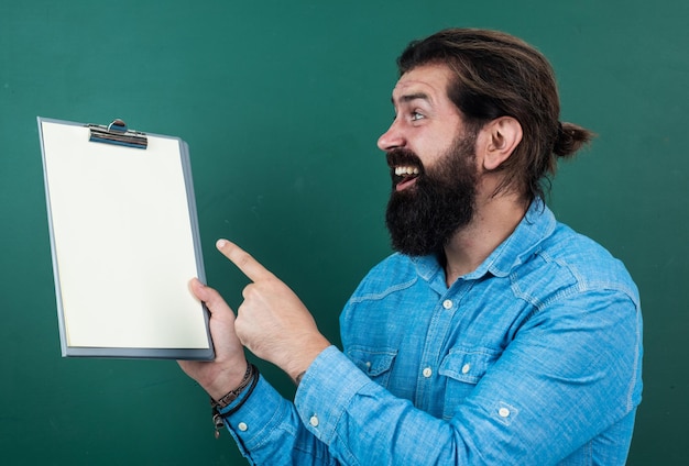 Apuesto hipster con barba y bigote mostrando papel de documento para hacer notas copia espacio anuncio