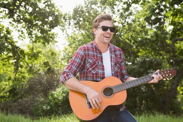 Apuesto hipster tocando la guitarra