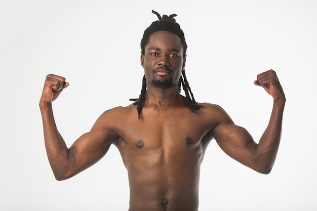 Apuesto hombre africano elegante con pelo rastas sobre un fondo blanco.