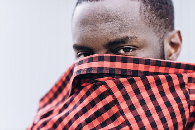 Foto apuesto hombre afroamericano que cubre su rostro