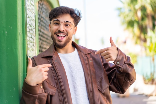 Apuesto hombre árabe al aire libre orgulloso y satisfecho de sí mismo