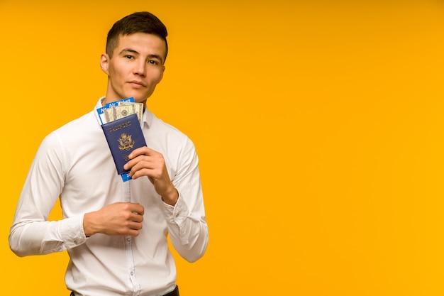 Un apuesto hombre asiático con una camisa blanca se regocija al ganar la lotería