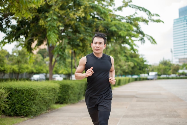 Apuesto hombre deporte corriendo en la ciudad al aire libre