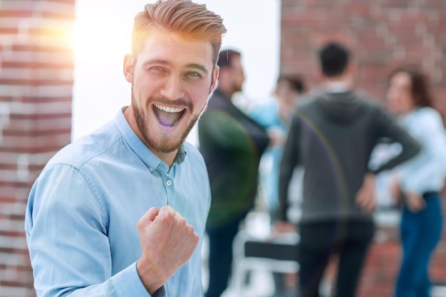 Apuesto hombre de negocios celebrando la victoria gritando alegremente en th