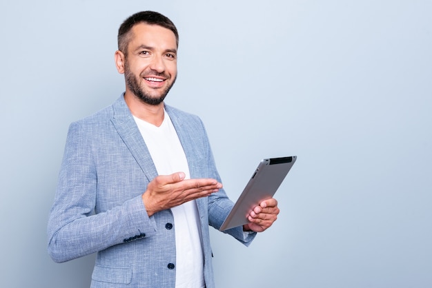 Apuesto hombre de negocios con una chaqueta azul posando contra la pared azul claro