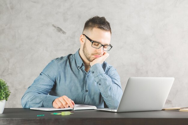 Apuesto hombre de negocios durmiendo en el lugar de trabajo