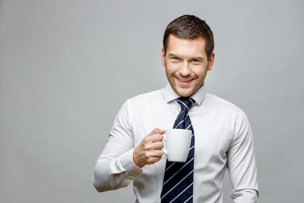 Foto apuesto hombre de negocios elegante sobre fondo gris