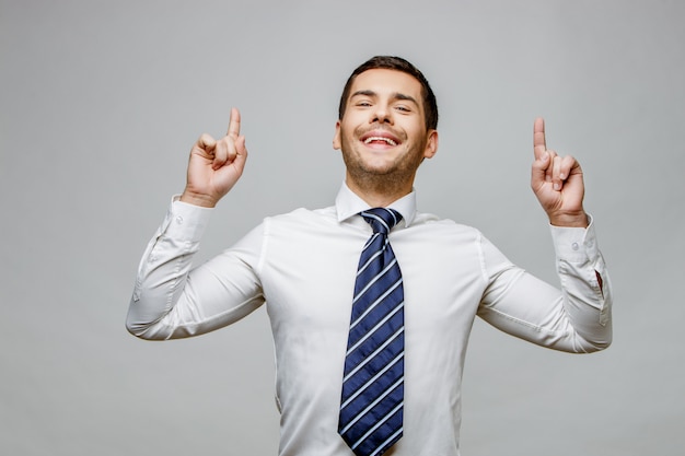 Apuesto hombre de negocios elegante sobre fondo gris