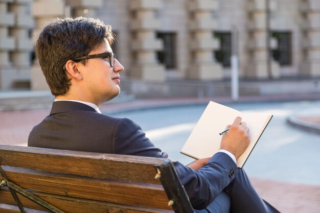 Apuesto hombre de negocios escribiendo en el bloc de notas