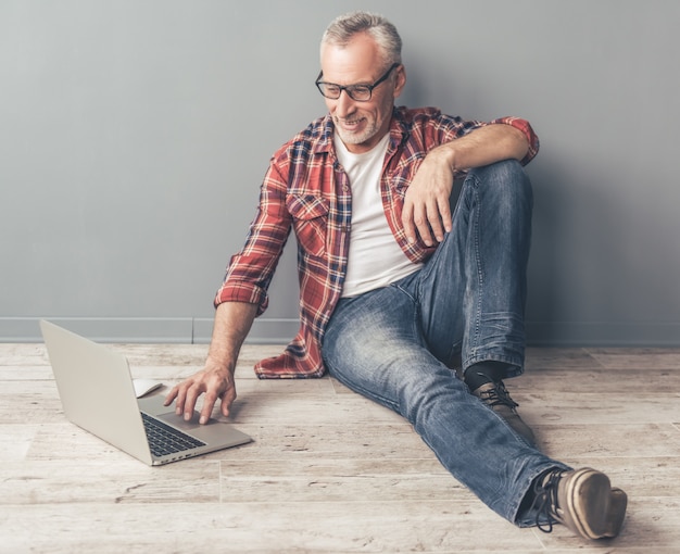 Apuesto hombre de negocios en gafas está utilizando una tableta digital.