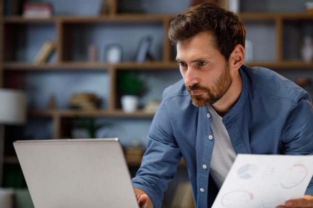 Apuesto hombre de negocios gerente trabajando detrás de una computadora portátil en una elegante oficina en casa trabajo remoto en ho