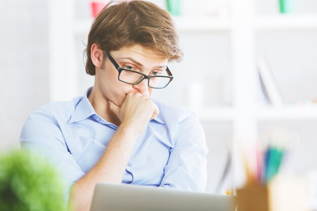 Apuesto hombre de negocios mirando la pantalla del portátil