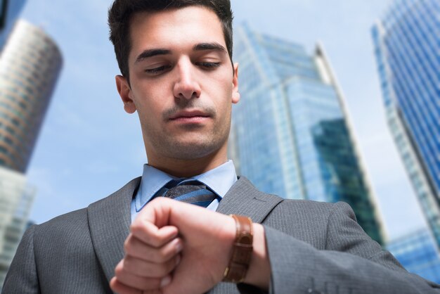 Apuesto hombre de negocios mirando su reloj