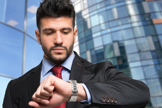 Apuesto hombre de negocios mirando su reloj