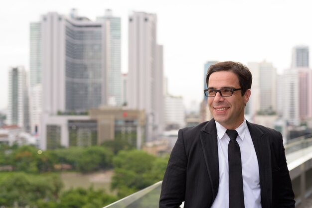 Foto apuesto hombre de negocios persa contra la vista de la ciudad