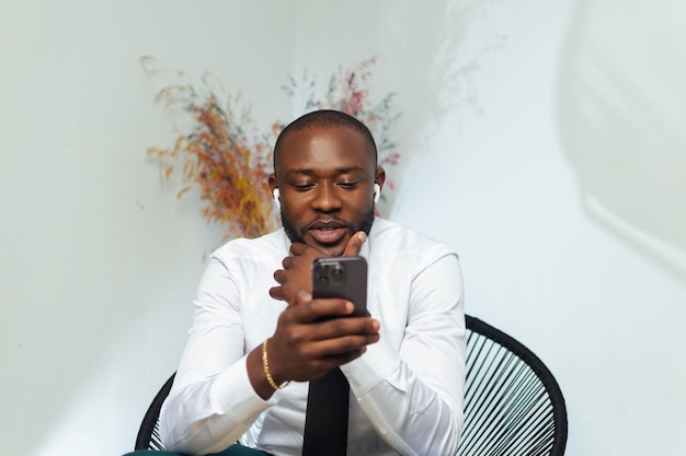 Apuesto hombre de negocios profesional africano negro sentado recibiendo una llamada de teléfono móvil