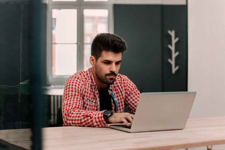 Foto apuesto hombre de negocios que trabaja con una computadora portátil en la oficina.