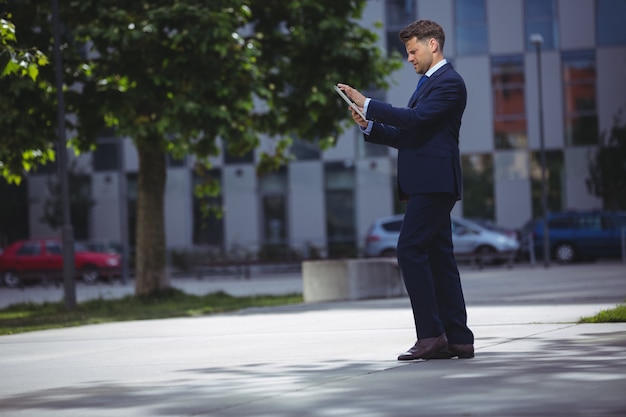 Apuesto hombre de negocios con tableta digital