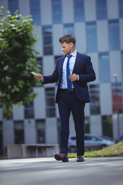 Apuesto hombre de negocios mediante teléfono móvil