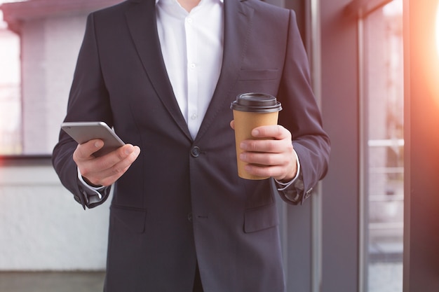 Apuesto hombre de negocios con un traje negro usando el teléfono