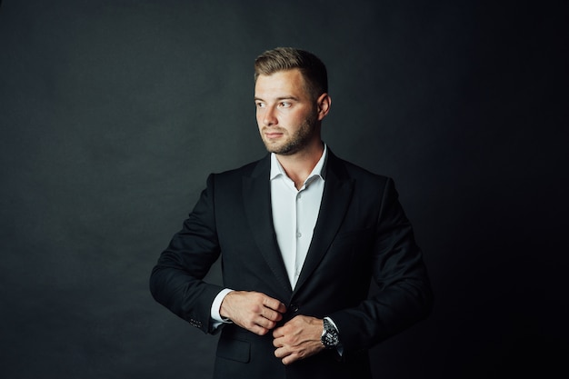 Apuesto hombre de negocios con traje posando en un estudio fotográfico. Retrato de medio cuerpo.