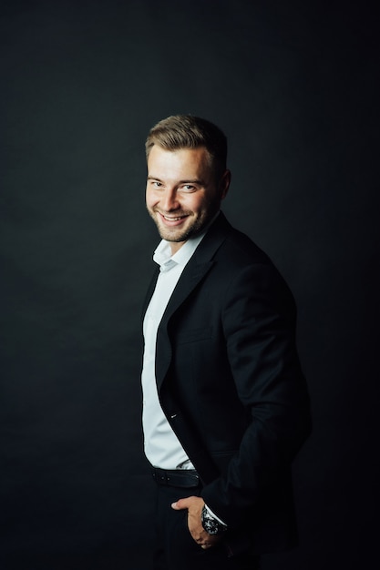 Apuesto hombre de negocios con traje posando en un estudio fotográfico.