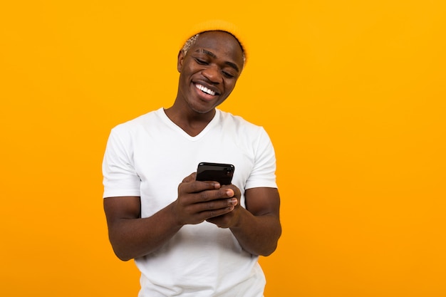 Apuesto hombre negro sonriendo mientras habla por teléfono en el