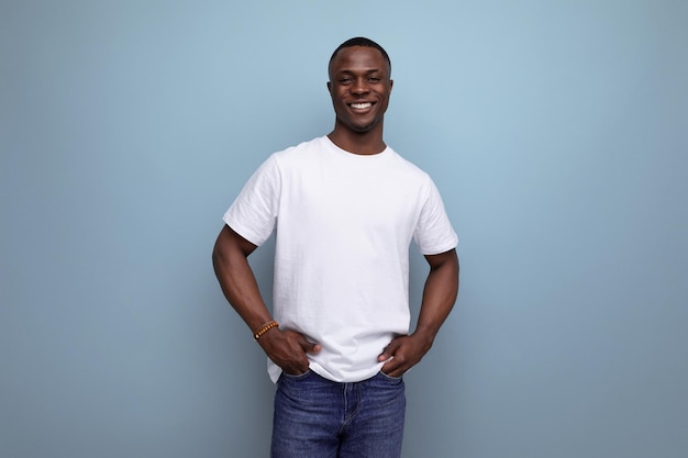 Apuesto joven africano en camiseta blanca sobre fondo azul con espacio de copia