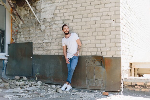 Un apuesto joven con barba en un interior de estilo grunge