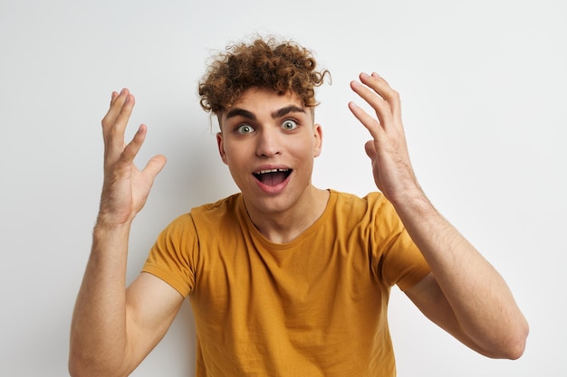 Foto apuesto joven en camisetas amarillas gesto manos emociones fondo aislado