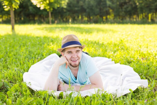 Apuesto joven en el campo, delante del campo con camisa, mirando a la cámara sonriendo