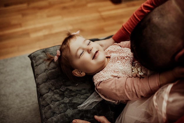 Apuesto joven en casa con su pequeña niña linda Feliz Día del Padre